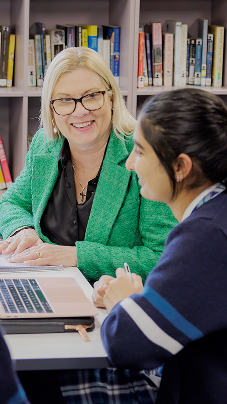 Caroline Chisholm Catholic College Glenmore Park student with dedicated teacher inside library