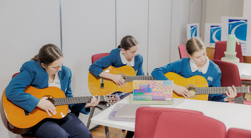 Caroline Chisholm Catholic College Glenmore Park students playing guitar