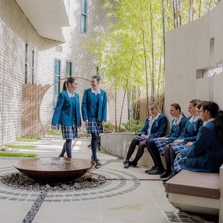 Caroline Chisholm Catholic College Glenmore Park students walking past water fountain on campus